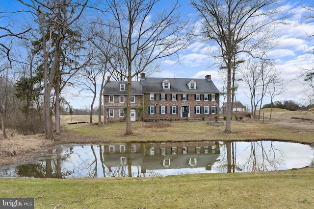 rear view of house featuring a yard and a water view