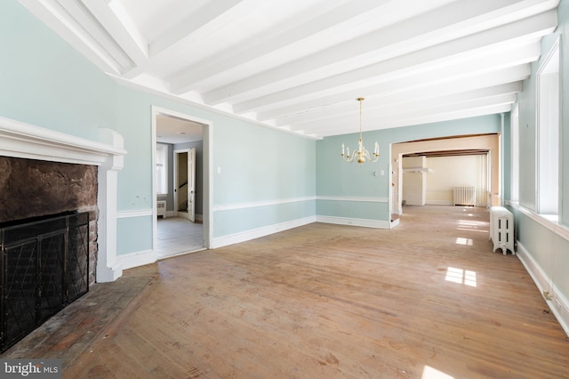 unfurnished dining area featuring an inviting chandelier, radiator, hardwood / wood-style floors, and beamed ceiling