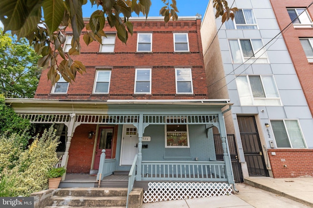 townhome / multi-family property featuring covered porch