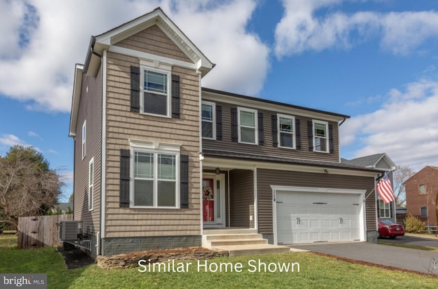 front of property with a garage, central AC, and a front yard