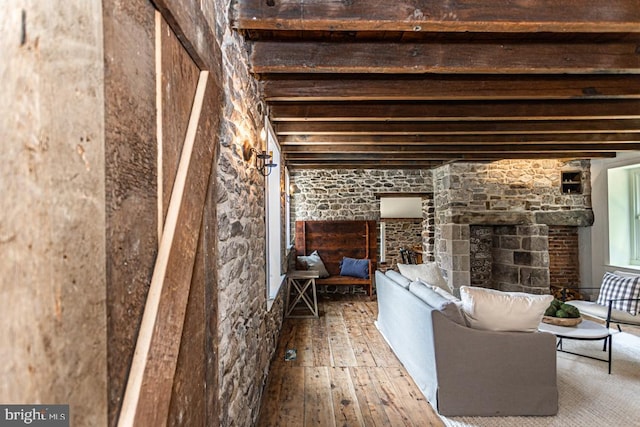 basement with wood-type flooring and a stone fireplace