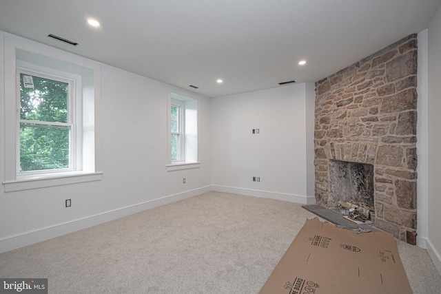 unfurnished living room featuring plenty of natural light, carpet floors, and a fireplace