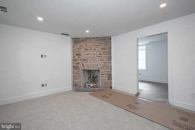 unfurnished living room with carpet flooring and a fireplace