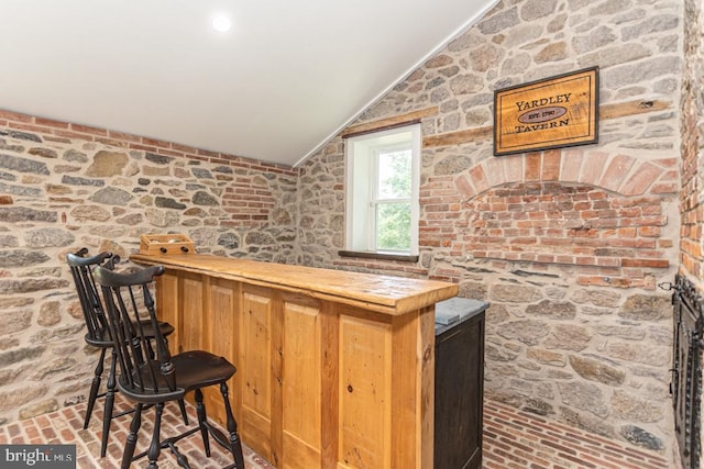 bar featuring lofted ceiling and butcher block countertops