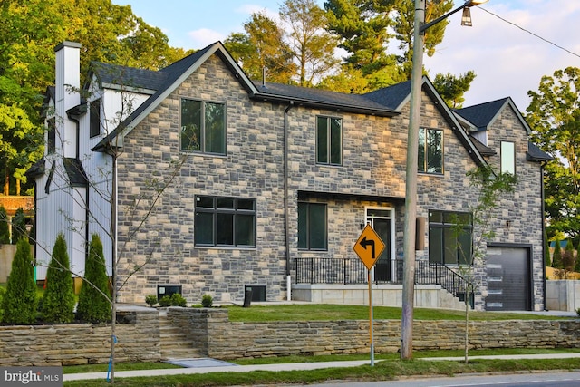 view of front facade with a garage and a chimney