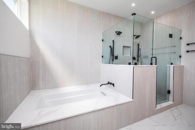 bathroom featuring tile patterned floors, separate shower and tub, vanity, and tile walls