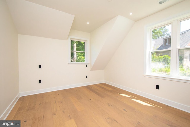 bonus room with lofted ceiling and light wood-type flooring