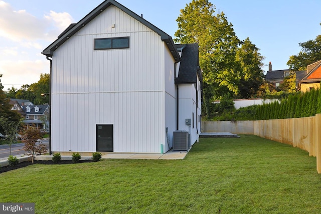 view of side of property featuring central AC and a lawn