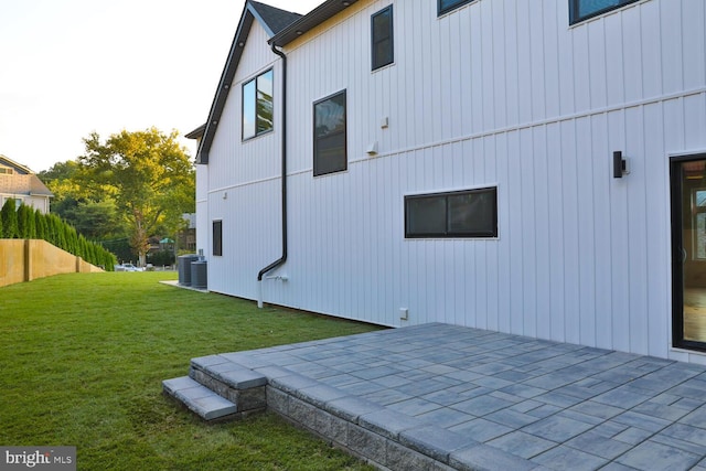 view of home's exterior with a patio, central AC, and a lawn