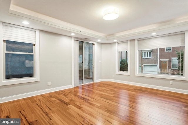 empty room featuring hardwood / wood-style flooring and a raised ceiling