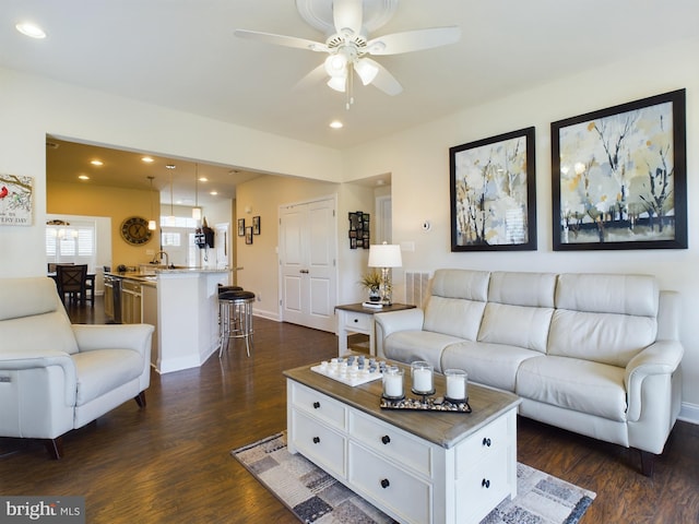 living room with ceiling fan, dark wood-type flooring, and sink