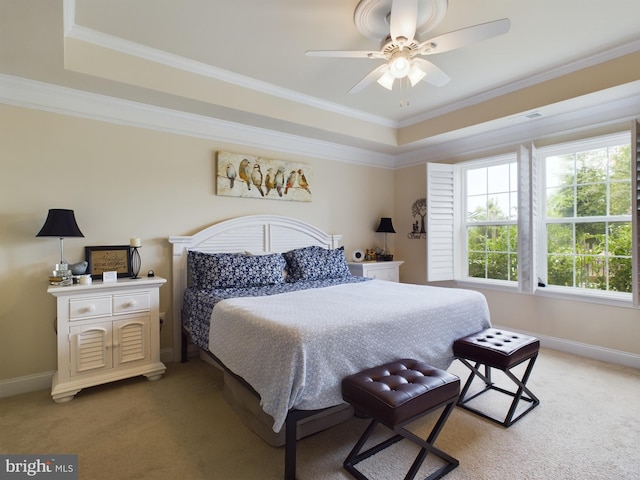 bedroom featuring a tray ceiling, carpet floors, ceiling fan, and crown molding