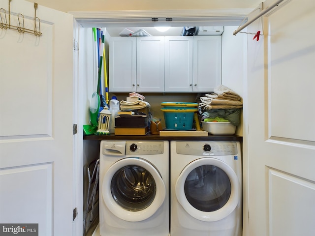 laundry area featuring washing machine and dryer and cabinets