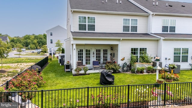 back of property featuring french doors, a patio, a shingled roof, a lawn, and a fenced backyard