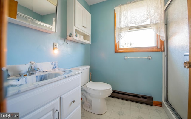 bathroom with a shower with door, vanity, a baseboard heating unit, and toilet