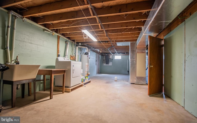 basement featuring electric panel, washer and clothes dryer, and water heater