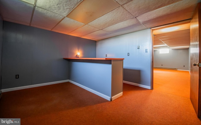 interior space with baseboard heating, a drop ceiling, and carpet flooring