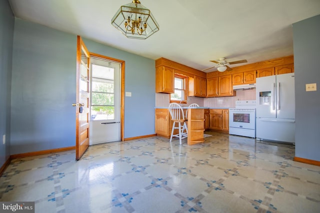 kitchen with decorative light fixtures, ceiling fan with notable chandelier, and white appliances