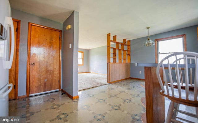 interior space featuring a chandelier, carpet floors, and plenty of natural light