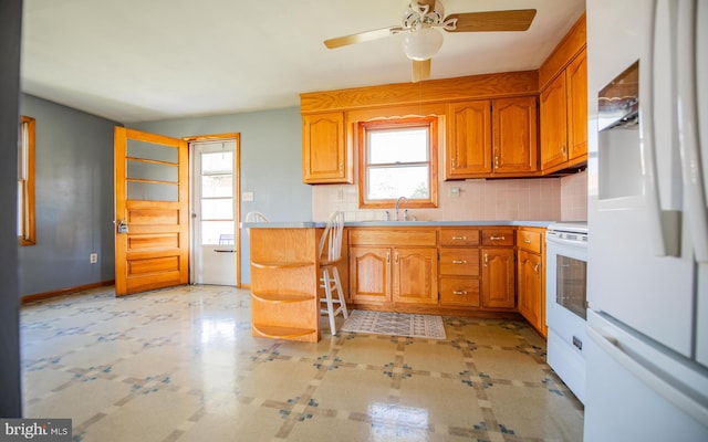 kitchen with white appliances, ceiling fan, tasteful backsplash, and sink