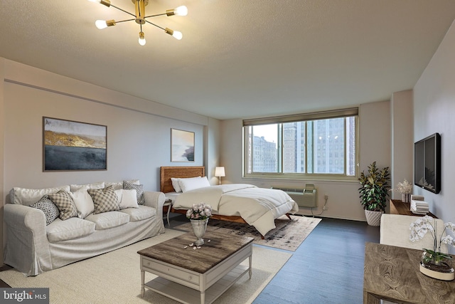 bedroom featuring hardwood / wood-style flooring, a notable chandelier, and an AC wall unit