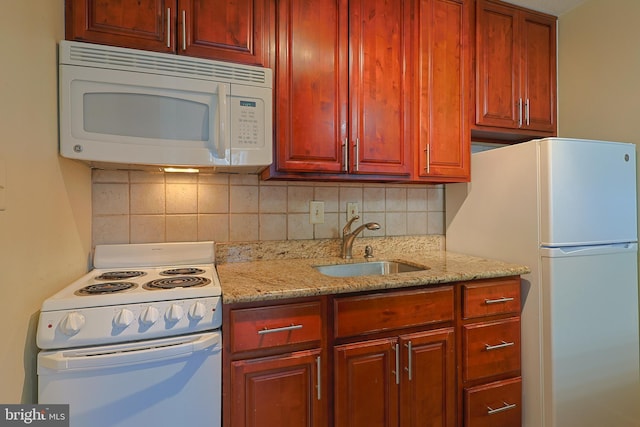 kitchen featuring tasteful backsplash, sink, light stone counters, and white appliances