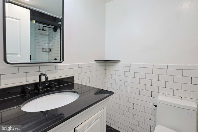 bathroom featuring vanity, toilet, and tile walls