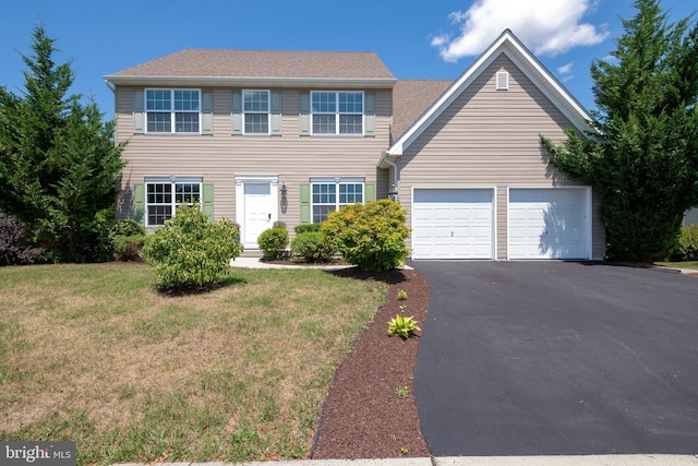 colonial inspired home with a garage and a front yard