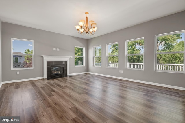 unfurnished living room with dark hardwood / wood-style floors and a chandelier