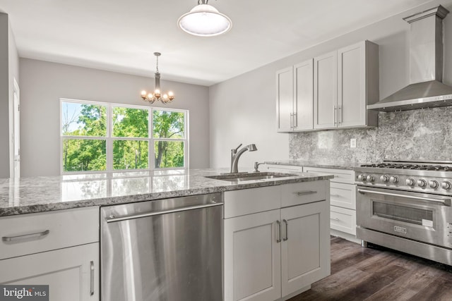 kitchen with appliances with stainless steel finishes, white cabinetry, sink, decorative backsplash, and wall chimney exhaust hood