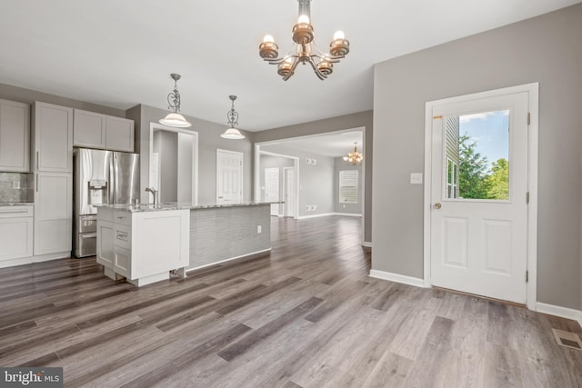 kitchen featuring pendant lighting, a notable chandelier, stainless steel fridge with ice dispenser, and gray cabinets