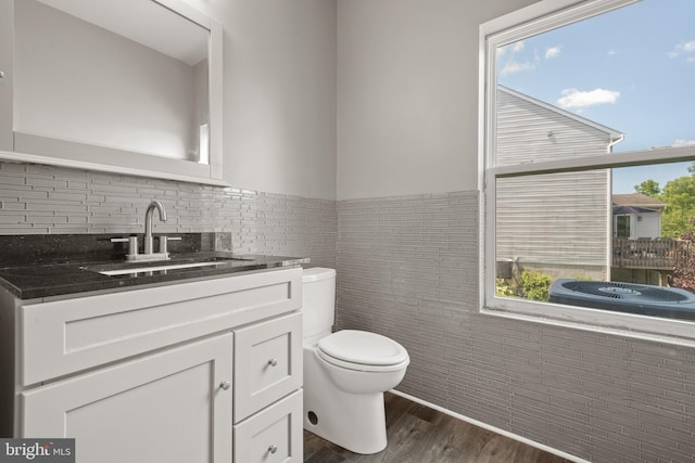 bathroom featuring hardwood / wood-style floors, vanity, a wealth of natural light, and toilet