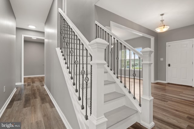 stairs featuring hardwood / wood-style floors