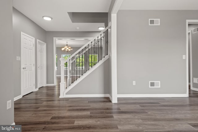 foyer featuring dark wood-type flooring and a chandelier