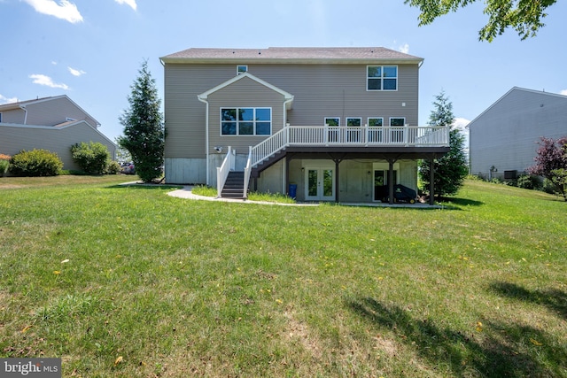 rear view of property featuring a wooden deck and a lawn