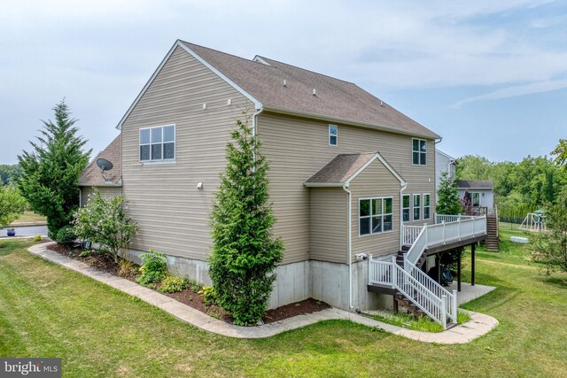 view of side of property featuring a yard and a deck