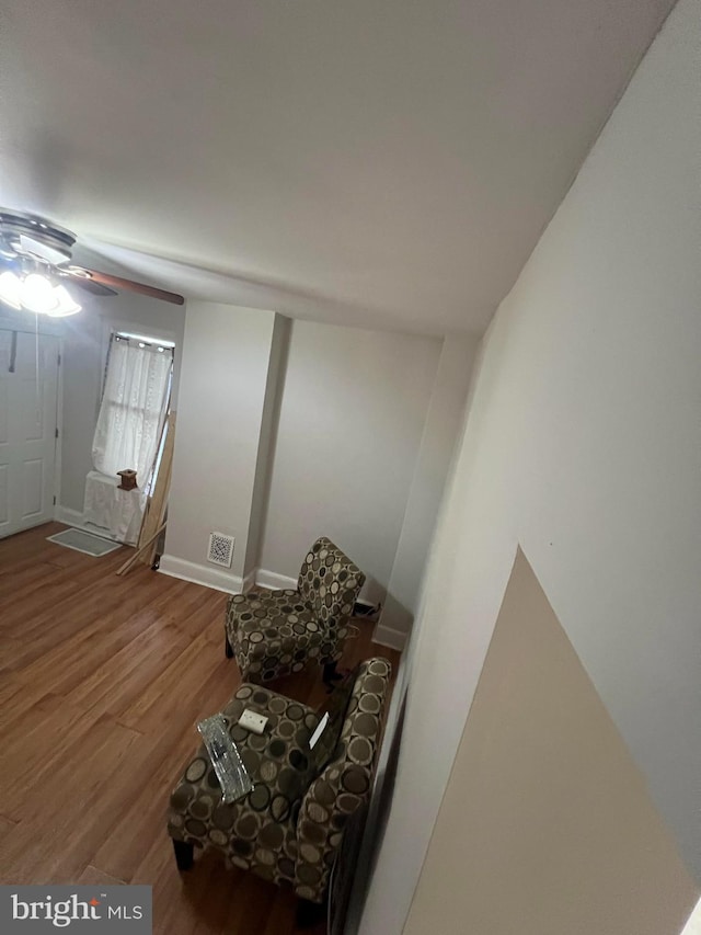 living area with hardwood / wood-style flooring and ceiling fan