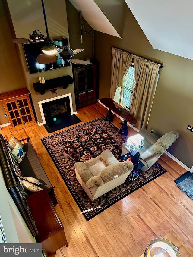 living room featuring hardwood / wood-style flooring, lofted ceiling, and ceiling fan