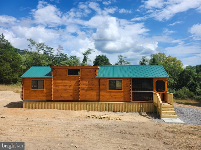 view of front of home featuring metal roof and log siding