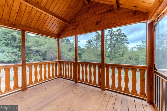 unfurnished bedroom featuring wooden ceiling, wood finished floors, beam ceiling, and wooden walls