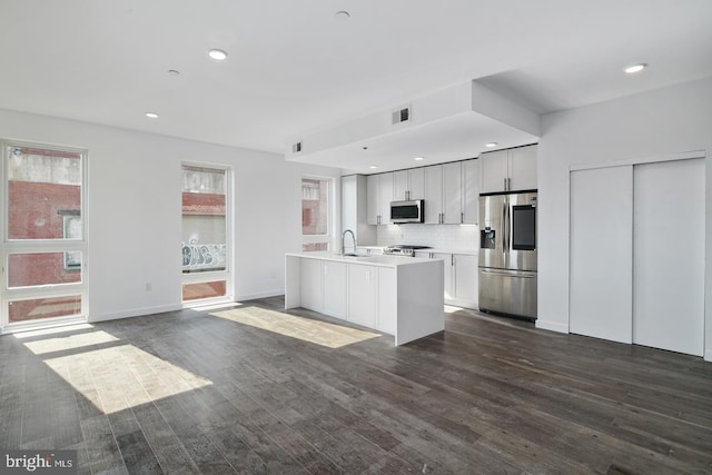 kitchen featuring white cabinetry, tasteful backsplash, stainless steel appliances, dark hardwood / wood-style flooring, and sink