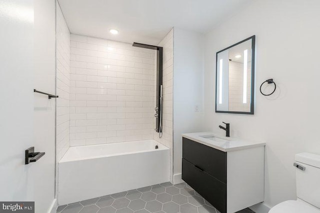 full bathroom featuring vanity, tile patterned flooring, tiled shower / bath, and toilet