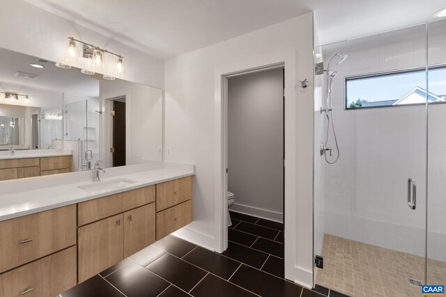 bathroom with vanity, toilet, an enclosed shower, and tile patterned flooring