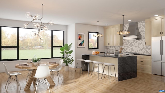 kitchen featuring a wealth of natural light, a chandelier, wall chimney exhaust hood, and appliances with stainless steel finishes