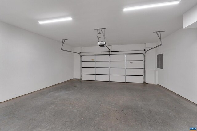 garage with a garage door opener and electric panel