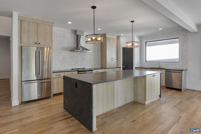 kitchen with backsplash, hanging light fixtures, a center island, stainless steel appliances, and wall chimney exhaust hood