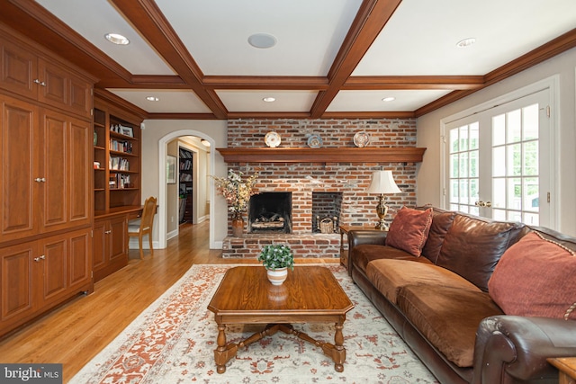 living room with french doors, coffered ceiling, beamed ceiling, a fireplace, and light hardwood / wood-style floors