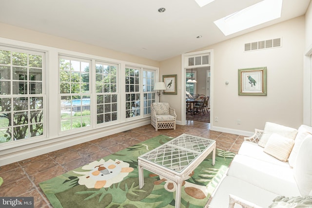 living room featuring vaulted ceiling with skylight