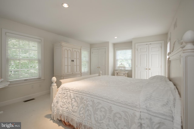 carpeted bedroom featuring multiple closets