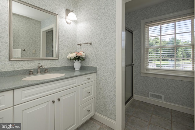 bathroom featuring vanity, an enclosed shower, and tile patterned flooring